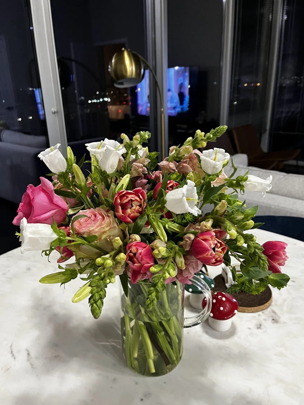 Pink roses, ranunculus and white lisianthus in a glass vase