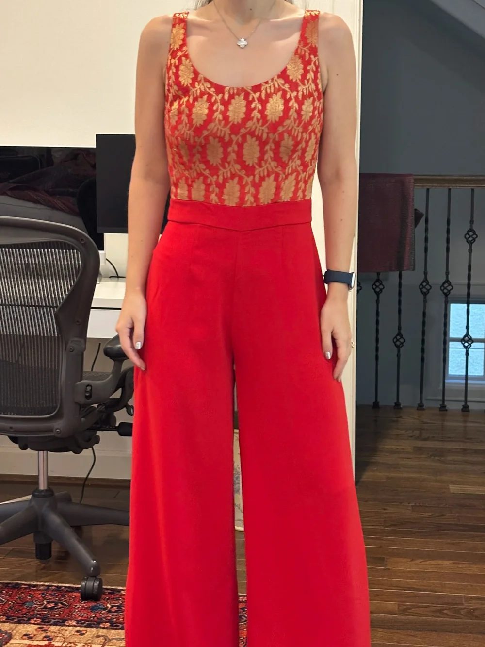 A red wide leg jumpsuit with a gold brocade bodice